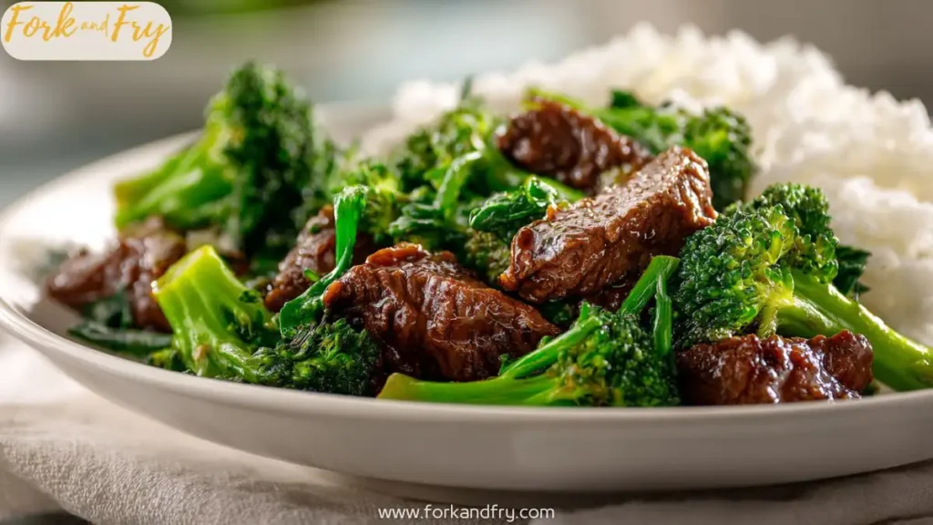 Glossy beef and broccoli stir-fry in brown sauce on white plate