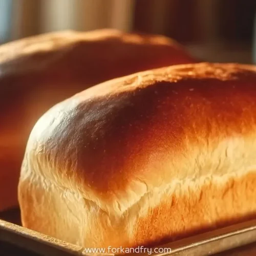 golden brown white bread loaves on a baking tray with soft crust