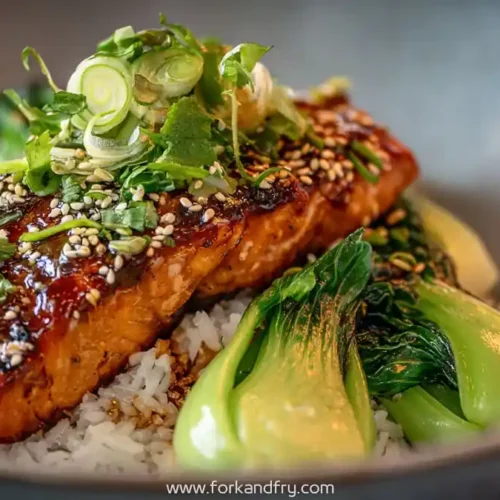 glazed miso salmon fillet on jasmine rice with baby bok choy scallions sesame seeds and cilantro garnish