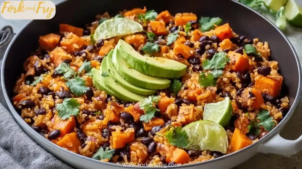 One-pan sweet potato black bean rice with avocado slices and lime wedges