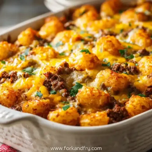 cheesy tater tot casserole with ground beef and parsley in white baking dish
