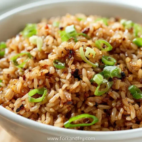 Chili garlic fried rice garnished with green onions in a white bowl, spicy no protein rice recipe