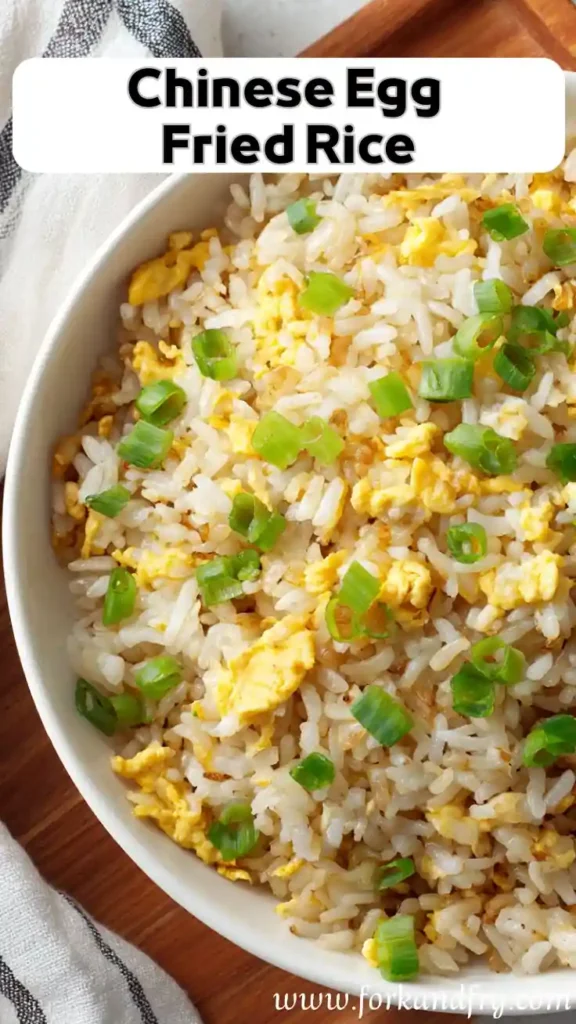 Best Chinese Egg Fried Rice – Easy Homemade Recipe overhead view of Chinese egg fried rice in a bowl with green onions on wood board