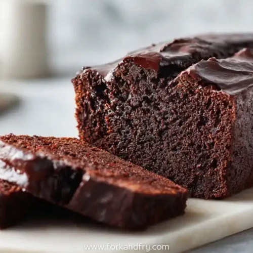 Sliced chocolate espresso banana bread with rich glaze on marble cutting board