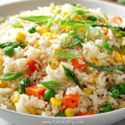 Freezer-friendly vegetable fried rice with corn, peas, carrots and scallions in a white bowl