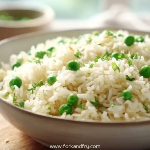 steamed white rice with green peas and herbs served in ceramic bowl