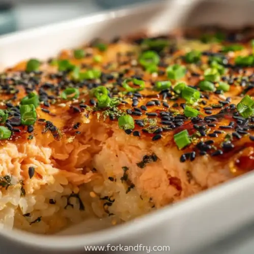 Salmon sushi bake with black sesame seeds, scallions, and rice in white casserole dish