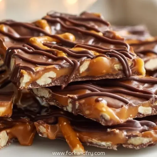 Salted caramel pretzel bark drizzled with rich chocolate on a white plate