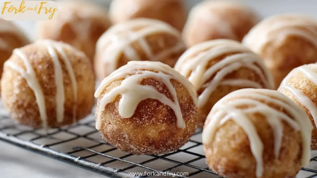 Cinnamon sugar donut holes with vanilla glaze on cooling rack, close-up