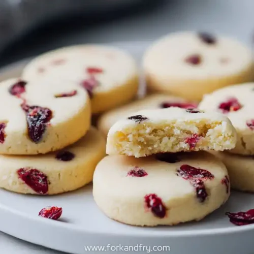 Buttery shortbread cookies with dried cranberries on a white plate