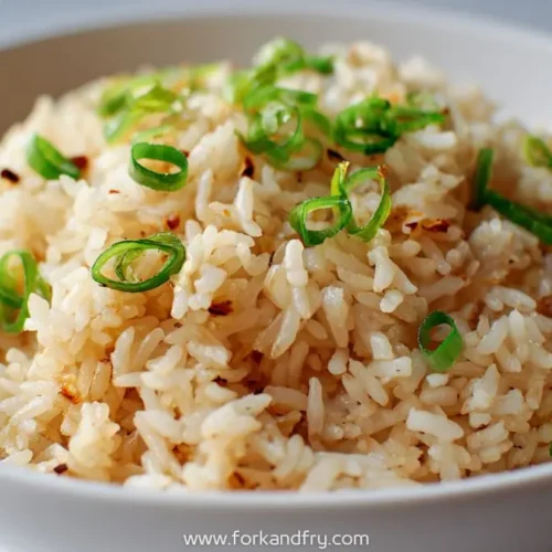 bowl of hibachi-style garlic rice topped with sliced green onions