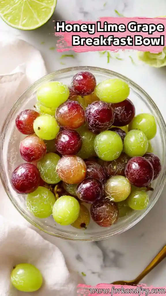 Fresh Grape Breakfast Bowl with Honey and Lime top view of red and green grapes in glass bowl with lime zest on white surface