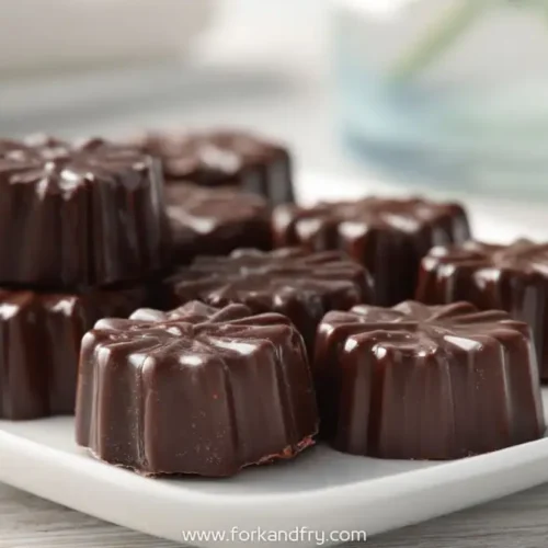 Flower-shaped chocolate marshmallow cream candies on a white plate