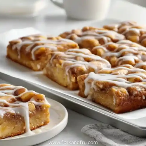 Glazed apple fritter bars baked in a sheet pan and sliced into squares