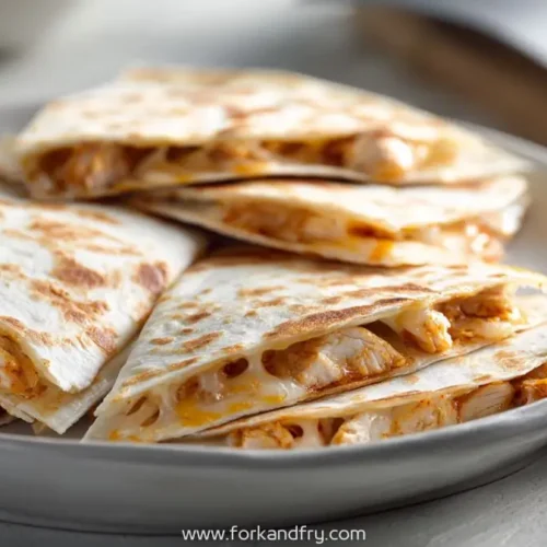 grilled sweet heat chicken quesadillas stacked on plate with golden cheese melt