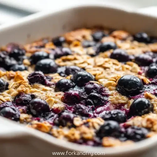 Blueberry baked oatmeal squares with oats and juicy blueberries in a white baking dish