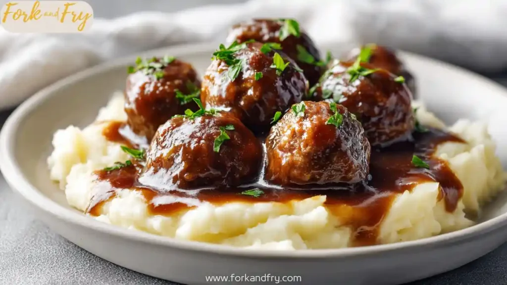 salisbury steak meatballs with brown gravy over mashed potatoes on plate