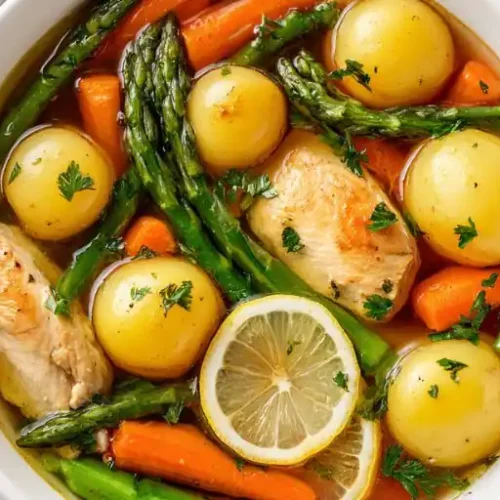 chicken vegetable soup with potatoes asparagus carrots and lemon slices in broth