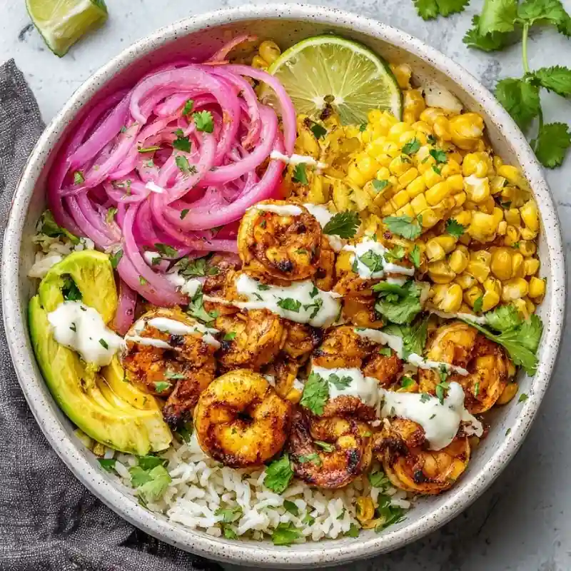 Spicy Shrimp Rice Bowl ā Easy Healthy Dinner Recipe Spicy shrimp rice bowl with avocado, pickled onions, grilled corn, cilantro, and creamy sauce